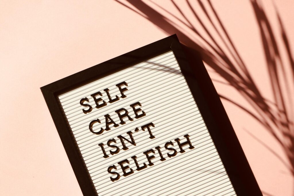 Picture of a placard with the words "Self care isn't selfish" written on it.